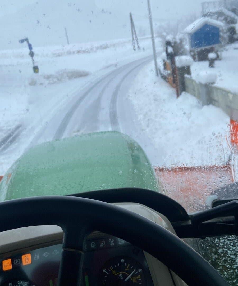 Traktor raeumt Schnee auf verschneiter Strasse – Forstservice-Krammer